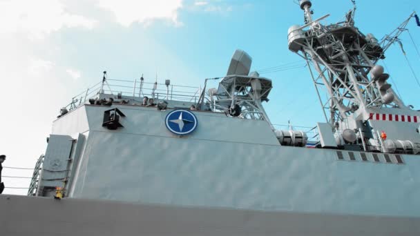 Odessa, Ukraine - September 2019: NATO military emblem aboard a warship. Several sailors go inside the ship — ストック動画