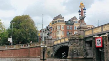 Amsterdam, Hollanda - Eylül 2019: Başkentin merkezindeki ortaçağ köprüsü. Kanaldan Amsterdam sokak manzarası