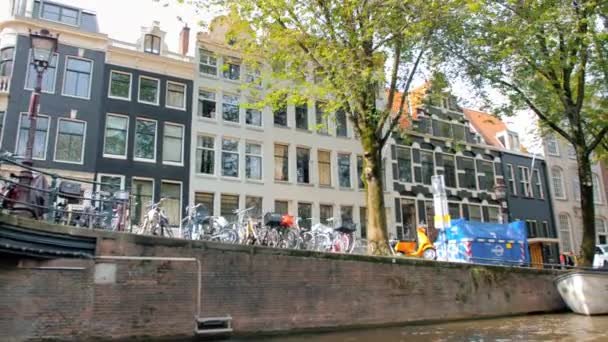 Amsterdam, Netherlands - September 2019: Amsterdam street view from the canal. Dumpster and cars parked next to the canal — Stock Video