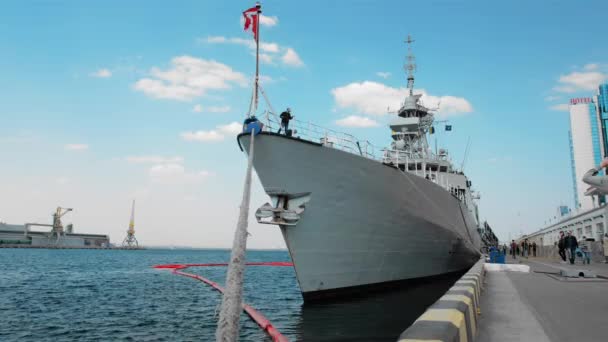 우크라이나 오데사: 2019 년 9 월: 밧줄에 의해 항구에 정박 한 뱃머리에 깃발을 단 캐나다 전함. 인지되지 않은 사람들은 지나간다 — 비디오
