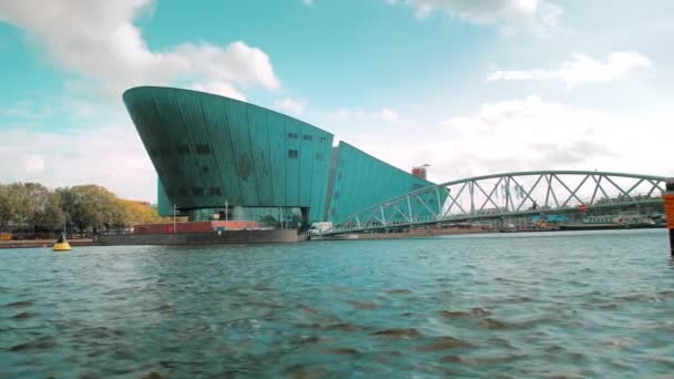Amsterdam, Alankomaat - syyskuu 2019: NEMO-museon moderni rakennusarkkitehtuuri. Näkymä Ij-joelta — kuvapankkivideo