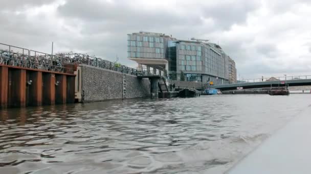 Amsterdam, Nederland - september 2019: Moderne bedrijfsarchitectuur van de hoofdstad. Uitzicht vanaf het kanaal. Het gebouw is gemaakt van glas in een bizarre vorm — Stockvideo