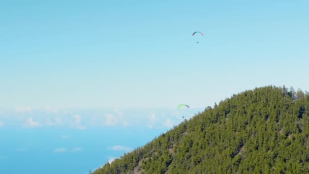 Twee paragliders silhouet vliegen over mistige bergvallei boven de wolken — Stockvideo