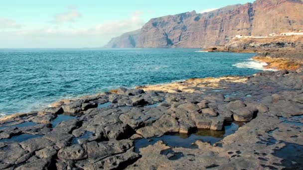 Bryta surfa på lava rock gul strand kastar spray i luften på kusten i Los Gigantes, Kanarieöarna. Atlanten — Stockvideo