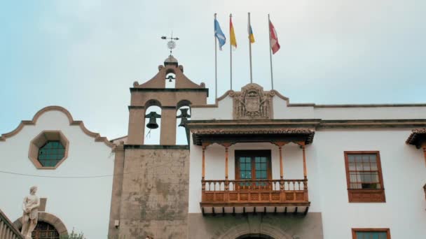 Tenerife, Canarische Eilanden, Spanje - januari 2019: Middeleeuws gebouw met vlaggen en klokkentoren in spanje. Gesneden houten balkon. — Stockvideo
