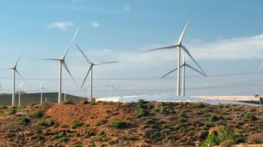 Elektrik üretmek için yel değirmenleri, arka planda yuvarlanan tepeler. Çevre koruma ve yeşil enerji kavramı