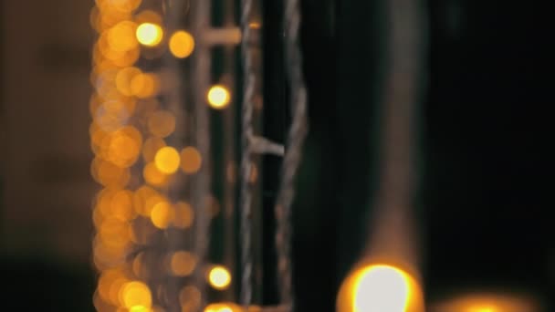 Feestelijke oudejaarsbloemenslingers en een mooie vage bokeh. Het kan als achtergrond worden gebruikt. Kerststemming. — Stockvideo