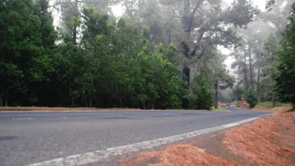 Carros dirigem ao longo de uma montanha nebulosa estrada lisonjeira. Conceito de visibilidade limitada e acidentes de viação — Vídeo de Stock