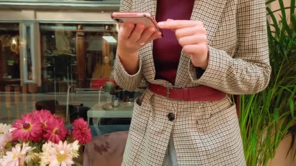 Een jonge vrouwelijke blogger, een influencer, maakt foto 's van koffie in een Parijse koffieshop op een smartphone. Retro-stijl koffieshop met vintage meubels — Stockvideo