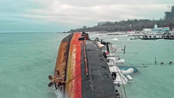 Bovenaanzicht van zinkende tanker neergeschoten door drone. Omgekeerde tanker gesloopt op de Zwarte Zee kust van Odessa. Lege tanker leunde naar een kant en liep aan de grond door tijdens storm met sterke wind. straalvliegtuig drone schot — Stockvideo