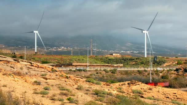 Kincir angin, turbin generator listrik dekat jalan raya dengan banyak lalu lintas mobil. Konsep hijau, terbarukan, energi bersih, konservasi lingkungan — Stok Video