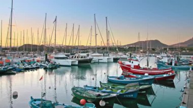 Las Galletas, Tenerife, Kanarya Adaları - Ocak 2019. Marina okyanusta. Körfeze demirlemiş lüks yatlar. Gün batımı güneş ışınları çok güzel aydınlatıyor. Arka planda dağlar ve yollar