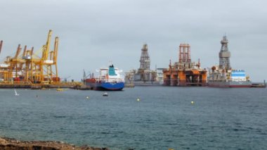 Petrol taşımak için birkaç petrol kulesi ve bir gemi tankeri. İskele vinçleri. Offshore petrol platformlarının onarımı ve inşası, küresel ısınma, karbon enerjisi.