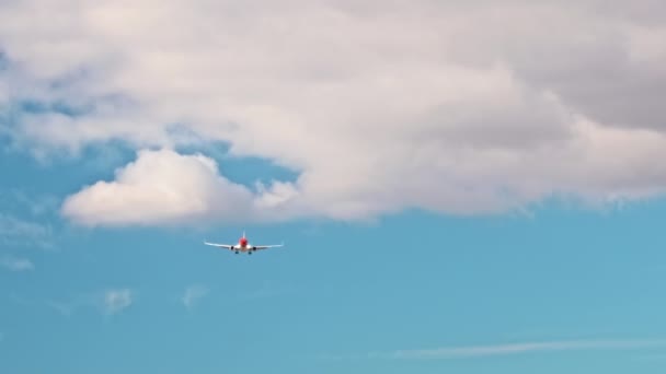 Fliegt das rote Düsenflugzeug mit losgelassenem Fahrgestell über den Himmel. Leichte Wolken — Stockvideo