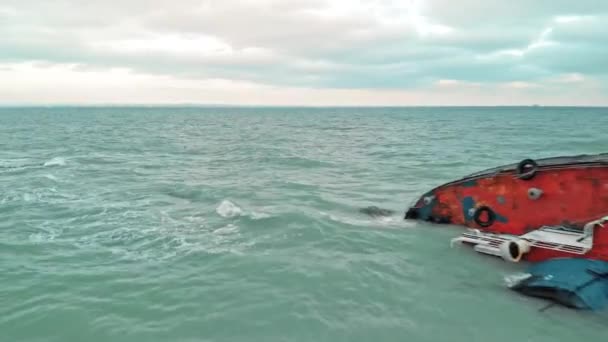 Vrachtschip, tanker liep aan de grond en rolde in de zee met golven in bewolkt weer. door de mens veroorzaakte ramp, verontreiniging van het mariene ecosysteem door emissies van het vaartuig. straalvliegtuig drone schot. — Stockvideo