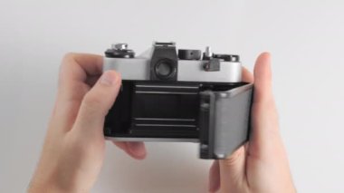 Tanınmayan bir adam, eski bir antika fotoğraf makinesinin gövdesini açar ve filmin yerini alır..
