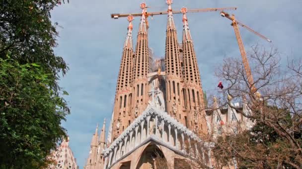 Барселона, Испания - февраль 2019 года: Саграда Фабрегас. Несколько строительных кранов возле собора. Концепция недостроенных зданий. Много туристов рядом с местом трагедии — стоковое видео