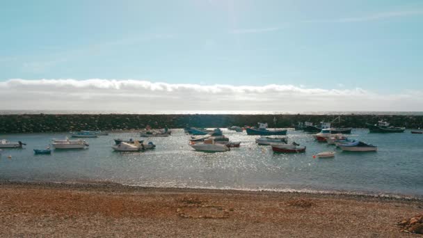 Marina cerca del océano. Una pequeña bahía en una ciudad española con barcos de pesca y yates de crucero. Rayos de sol en la superficie del mar — Vídeos de Stock