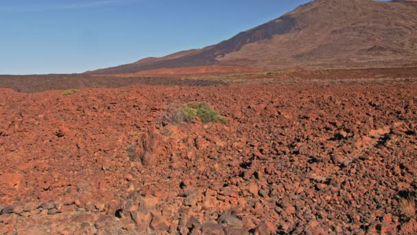 Wulkaniczny krajobraz. Czerwony kamień rock i szczyt wzgórza w tle. Może służyć do zilustrowania życia na Marsie, lądowania astronautów na innej planecie.. — Wideo stockowe