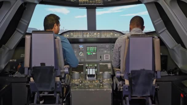 两名不明身份的多种族男子在飞机驾驶舱。训练飞机的模拟器飞行员。大型飞机飞行员的概念培训、飞行前准备. — 图库视频影像