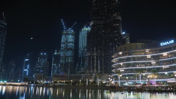 Dubai, Emiratos Árabes Unidos - febrero de 2020: Increíble actuación, fuentes musicales de Dubái. Rascacielos altos y grúas de construcción en el fondo . — Vídeo de stock