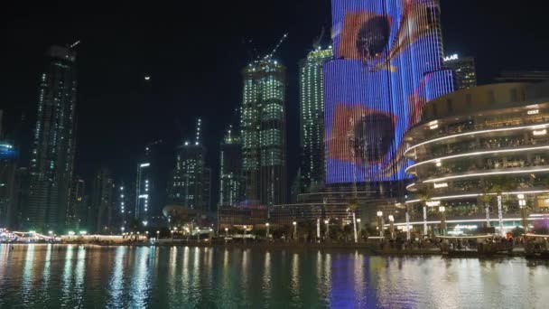 Dubai, Emirati Arabi Uniti - Febbraio 2020: Illuminazione colorata sull'edificio più alto del mondo Burj Khalifa. Il lago vicino al centro commerciale Dubai. Grattacieli in costruzione e lo skyline — Video Stock