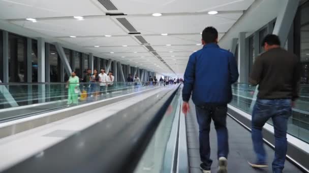 Dubai, United Arab Emirates - February, 2020: People of different races walk down the escalator in the subway or shopping center — Stock Video