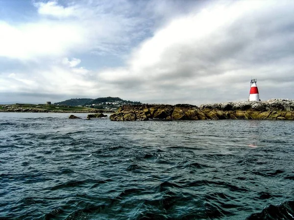 Petite île avec un phare rouge et blanc Symbole de sécurité dans le cadre de la navigation sur la côte près de Dublin en Irlande — Photo
