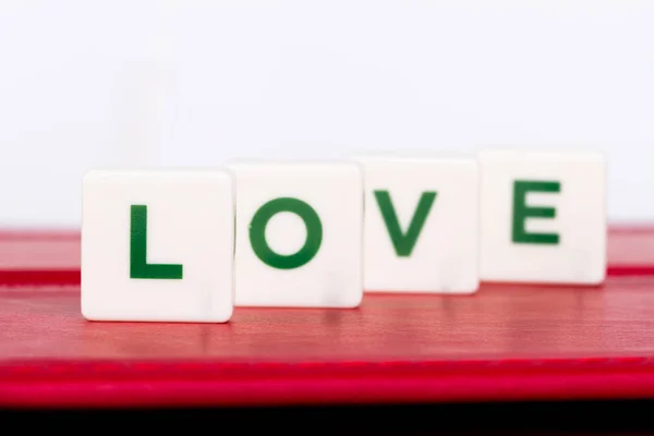 Palavra amor com letras no fundo vermelho — Fotografia de Stock