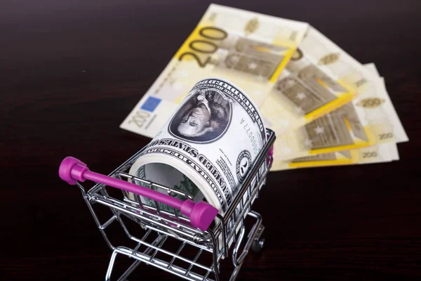 Dollar and Euro Banknotes with Shopping Cart Consuming Concept