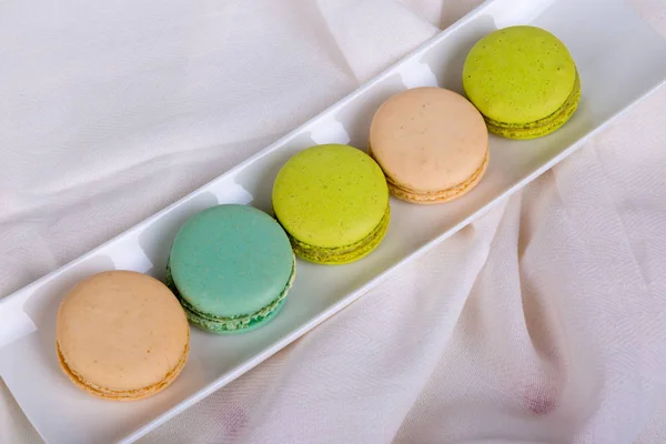 Macarons gostosos servidos na placa branca — Fotografia de Stock