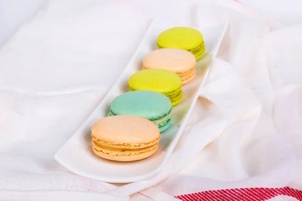 Macarons gostosos servidos na placa branca — Fotografia de Stock