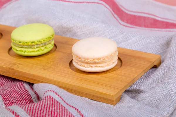 Macarons gostosos coloridos em placa de madeira — Fotografia de Stock