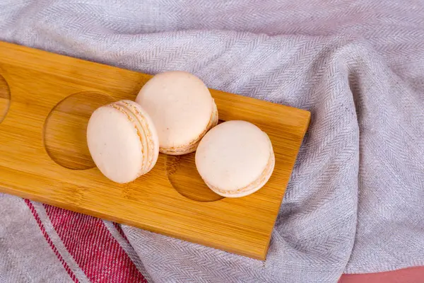 Macarons gostosos coloridos em placa de madeira — Fotografia de Stock