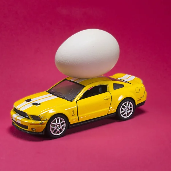 chicken eggs on toy car on white background with blank card. Abstract retro concept.