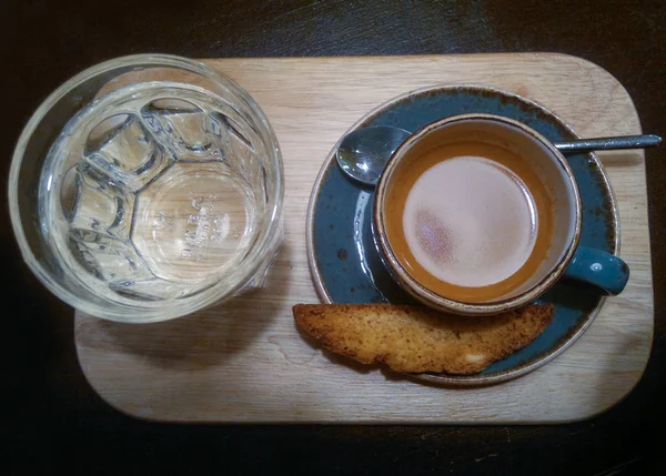 Голубая тарелка и кофейная чашка на деревянном подносе и стакан воды — стоковое фото