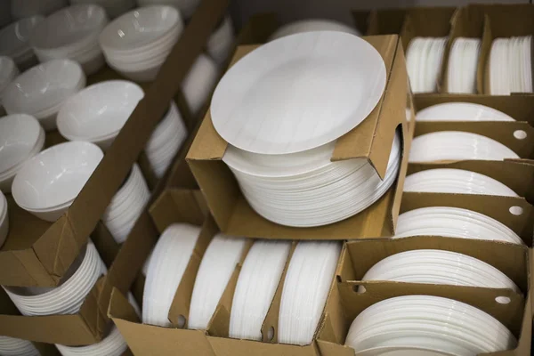 Белые тарелки в упаковке на полке — стоковое фото