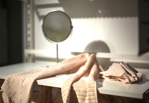 Полотенце на белой полке в ванной комнате и круглое зеркало — стоковое фото