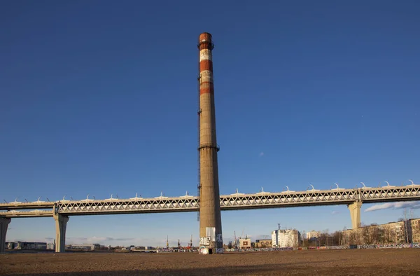 一座高耸的混凝土厂房烟囱和一条高耸蓝天的公路 — 图库照片