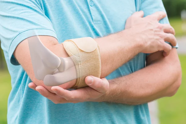 Man bär armbåge stag — Stockfoto