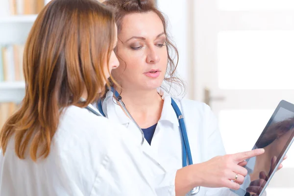 Duas mulheres médicos olhando para tablet — Fotografia de Stock