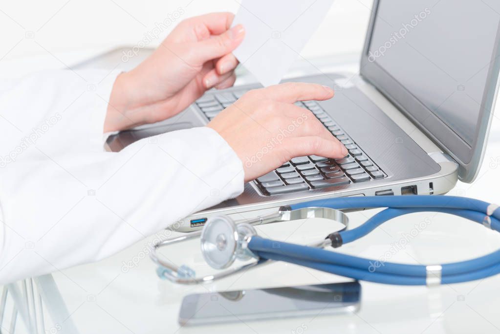 Medical doctor typing on laptop