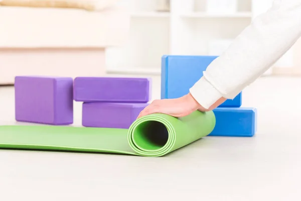 Rolling up a yoga mat — Stock Photo, Image