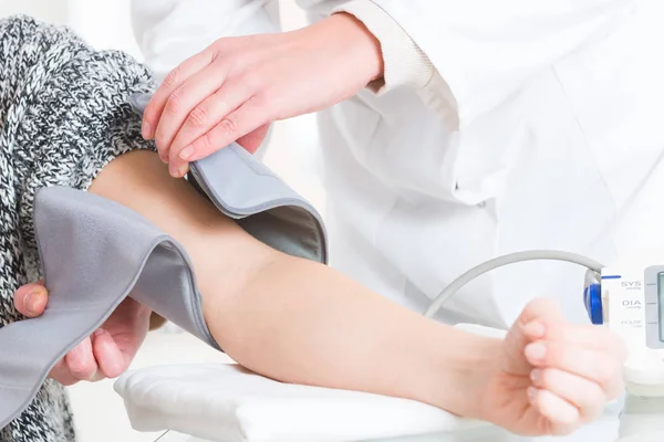 Doctor measuring blood pressure — Stock Photo, Image