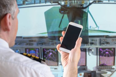 Airline pilot using smart phone clipart