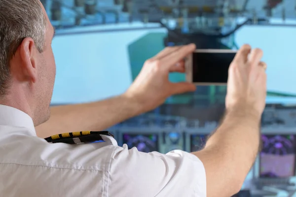 Airline pilot använder smart telefon — Stockfoto