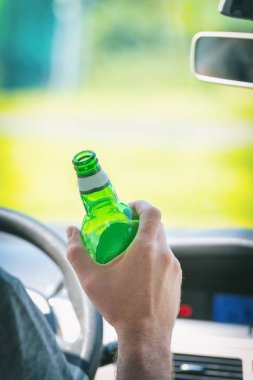 Man drinking beer while driving a car clipart