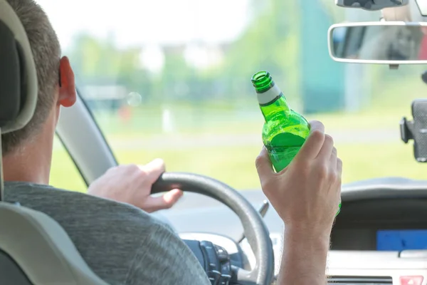 Hombre bebiendo cerveza mientras conduce un coche — Foto de Stock