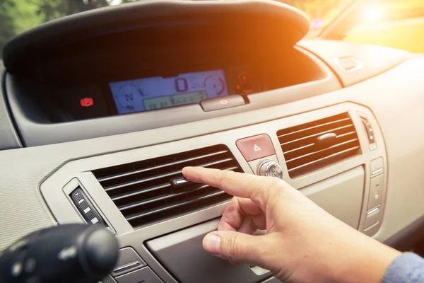 Driver hand tuning air ventilation grille — Stock Photo, Image