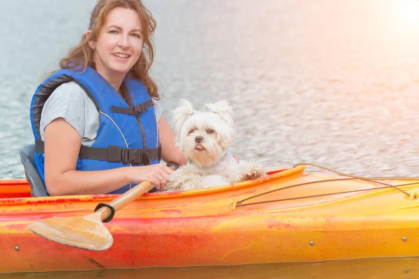 Vrouw en haar hond op een kajak — Stockfoto